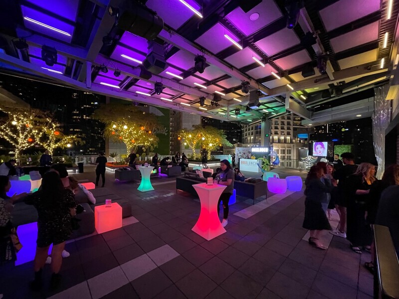 LED lit tallboy tables and lounge seating fill The Rooftop Terrace space at night.