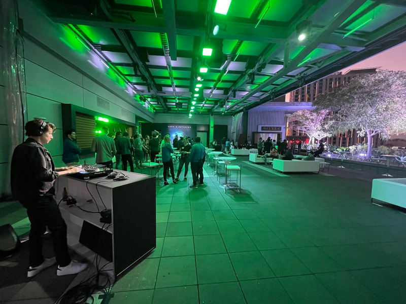 A DJ set up with green lighting at The Rooftop Terrace.