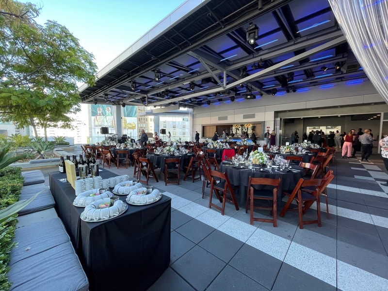 A daytime look at The Rooftop Terrace prepared for an event with dining tables and a buffet. 